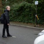 child crossing road in between two parked cars