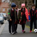 children walking and kicking a football