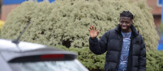 child waving at a person in a car