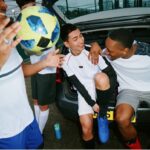 A group of mates getting ready for 5-a-side sat on the car boot.